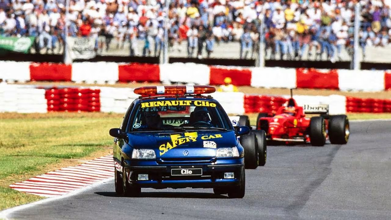 Safety car de Formule 1 gyrophares allumés menant le peloton sur la piste