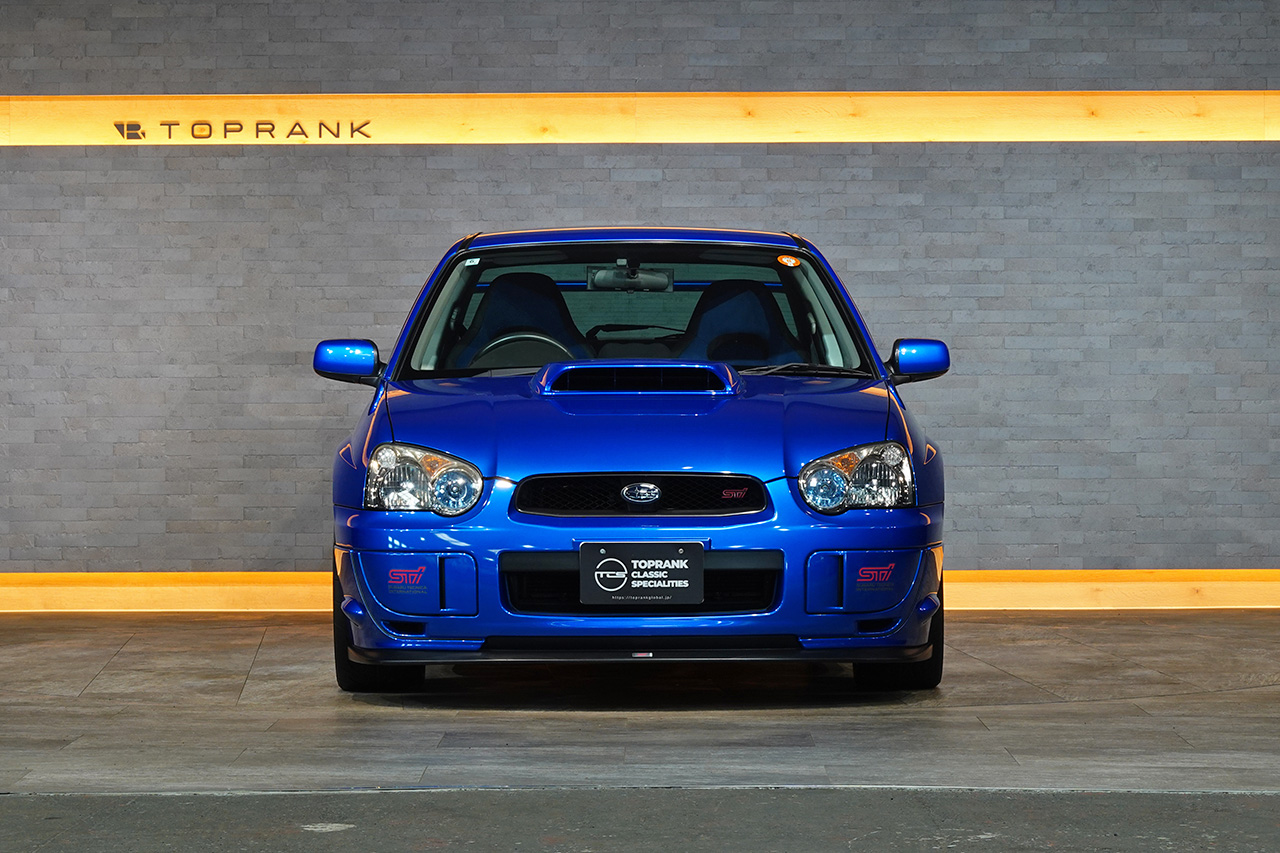 Subaru Impreza WRX STI 2004 bleue avec jantes dorées, vue de trois quarts avant